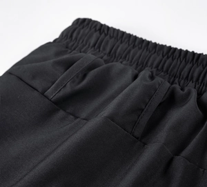 Detailed macro view of the elastic waistband and back pocket of black men's sports pants