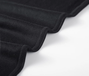 Detail of black sports trousers showing premium double-stitched hem and elastic knit fabric