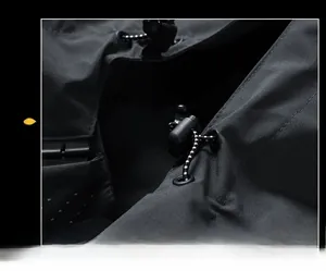 Close-up of adjustable elastic drawstring and plastic buckle on black outdoor jacket