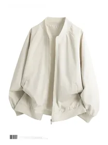 Flat lay view of a minimalist beige baseball jacket with ribbed cuffs and classic zipper detail