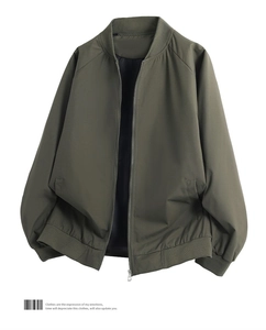 Close-up detail of military green bomber jacket with ribbed collar and zip closure