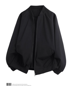 Close-up of black bomber jacket featuring ribbed collar and smooth zipper closure detail