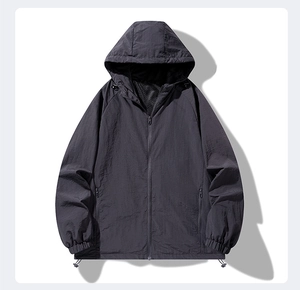 Detail view of charcoal grey hooded windbreaker featuring elastic cuffs and zipper pockets