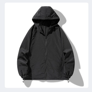 Detail shot of black windproof hooded jacket showing textured fabric and zipper pockets