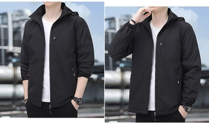 Close-up of black windbreaker jacket showing zipper pockets and adjustable hood detail