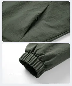 Dettaglio della giacca outdoor verde militare con tasca con zip e polsini elasticizzati