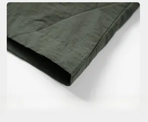 Dettaglio della cucitura dell'orlo e della trama in nylon della giacca outdoor verde