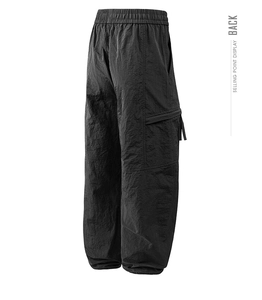 Detail view of the elastic waistband and spacious cargo pockets on black nylon trousers