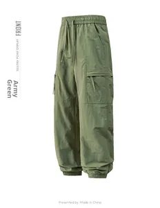 Detail of army green cargo pants featuring elastic drawstring waist and side flap pockets