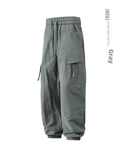 Detailed view of grey cargo pants featuring drawstring waist and functional flap pockets