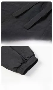 Detail of adjustable drawstring waistband and high elastic ribbed cuffs on black joggers
