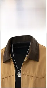 Close-up of casual jacket with dark brown corduroy collar and silver pendant detail