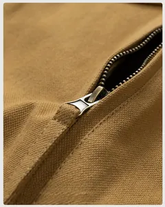 Detail of vintage bronze metal zipper on thick khaki canvas jacket fabric