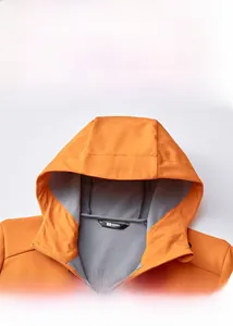 Detailansicht der orangefarbenen Outdoor-Softshelljacke mit Kapuzenkragen und Halsschutz