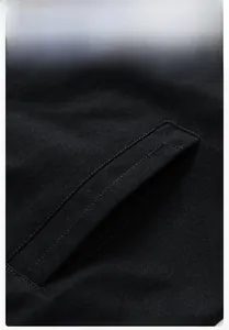 Detailed close-up showing high-density black twill fabric texture and precise pocket stitching