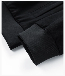 Detail of ribbed cuffs and hem on black casual jacket showing premium fabric texture