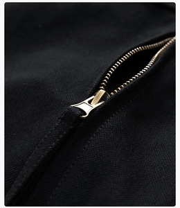 Macro detail of the premium gold-tone metal zipper on a black casual jacket sleeve