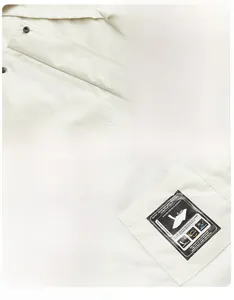 Detail of outdoor jacket showing snap cargo pockets and internal zippered mesh pocket
