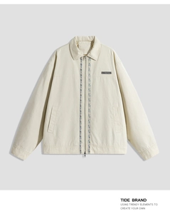 Detail of vintage workwear jacket with floral embroidery and branded woven chest patch