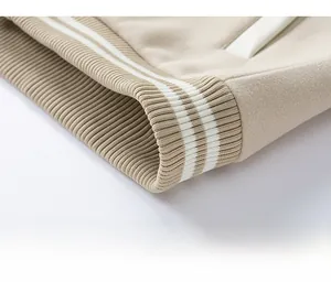 Dettaglio del bordo a coste con strisce bianche su una giacca baseball beige