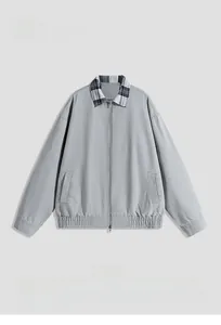 Detail of grey workwear jacket with checkered collar accent and zipper closure