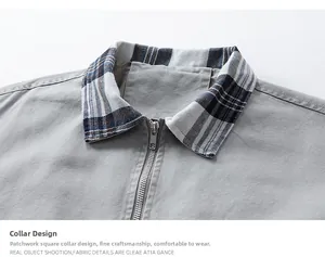 Detail of grey workwear jacket with blue plaid collar and silver metal zipper