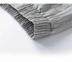 Detailed close-up of elastic ribbed hem on a grey American style patchwork cargo jacket