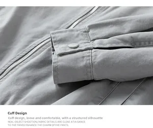 Detailed close-up of gray workwear jacket sleeve with silver snap button and metal zipper