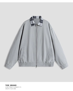Detail of grey work jacket with plaid collar and durable metal double zipper