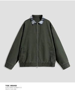 Detail of dark green work jacket showing plaid拼接 collar and premium metal zipper