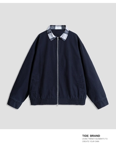 Detail of navy work jacket featuring a dual-layer checkered collar and metal zipper