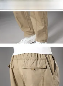 Detail view of khaki cotton cargo pants featuring back flap pockets and straight leg cuffs