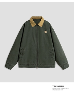 Detail of vintage green work jacket with khaki collar and NY diamond badge on the chest