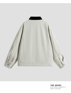 Detail of the workwear jacket back with black corduroy collar and beige canvas texture