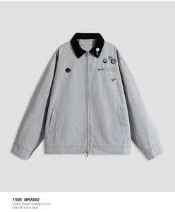 Detail of gray jacket with corduroy collar and colorful fashion badges on chest