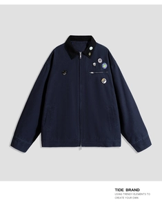 Detail of dark blue workwear jacket with corduroy collar and trendy streetwear pins