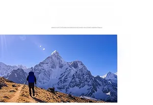 Close-up of durable hiking backpack and trekking poles on a mountain trail with snow peaks