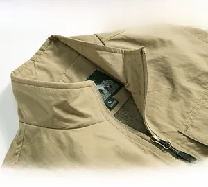 Detail showing khaki stand-up collar vest with metal zipper and breathable mesh lining