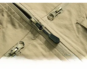 Close-up of durable antique bronze metal zippers and stitching on khaki utility vest
