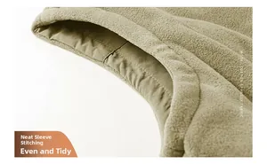 Gros plan sur les coutures précises et la texture polaire douce sur la manche d'un gilet kaki
