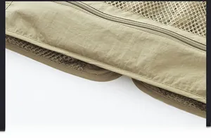 Detail of khaki functional vest hem featuring durable stitching and breathable mesh lining