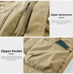 Detail of khaki outdoor vest showing durable zipper and anti-theft pocket with phone
