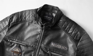 Detail der schwarzen Bikerjacke mit gesteppten Schultern und Stickerei-Abzeichen