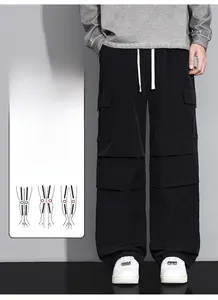 Detail of black baggy cargo pants featuring white drawstrings and multiple utility pockets