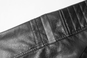 Makrodetail der gerippten Steppung an der schwarzen Herren-Bikerjacke aus PU-Leder matt