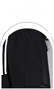 Detail showing elastic drawstring waistband and cargo flap pocket on black utility pants