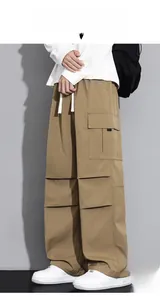 Detail view of khaki cargo pants with large side flap pockets and adjustable white drawstring