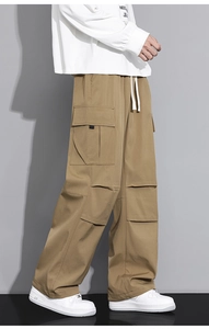 Detail of khaki cargo pants featuring large side pockets and drawstring elastic waist