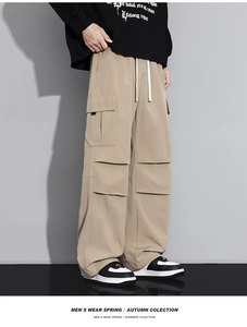Detail of khaki cargo pants featuring large flap pockets and a wide-leg street style fit