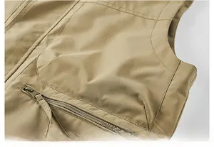 Detail of khaki functional vest showing shoulder seam and zipper pocket with fabric puller